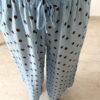 Femme portant un pantalon bleu ciel à pois marron avec taille élastique et lien de serrage, associé à un haut uni.