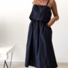 Robe midi bleu marine pour femme à bretelles nouées, coupe ample et fluide avec poches, style bohème chic et élégant.