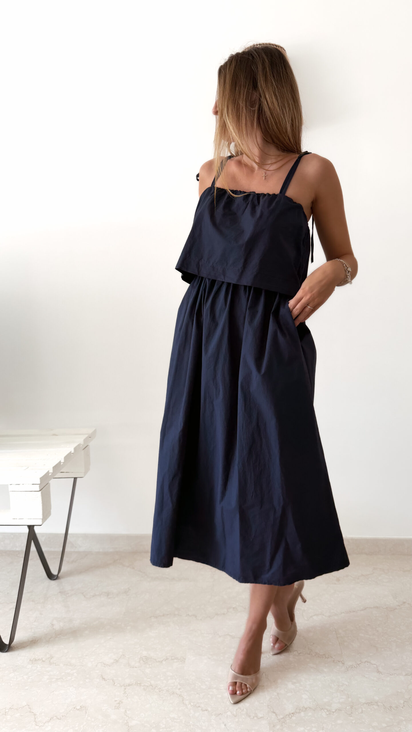 Robe midi bleu marine pour femme à bretelles nouées, coupe ample et fluide avec poches, style bohème chic et élégant.