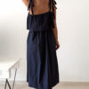 Robe midi bleu marine pour femme à bretelles nouées, coupe ample et fluide avec poches, style bohème chic et élégant.