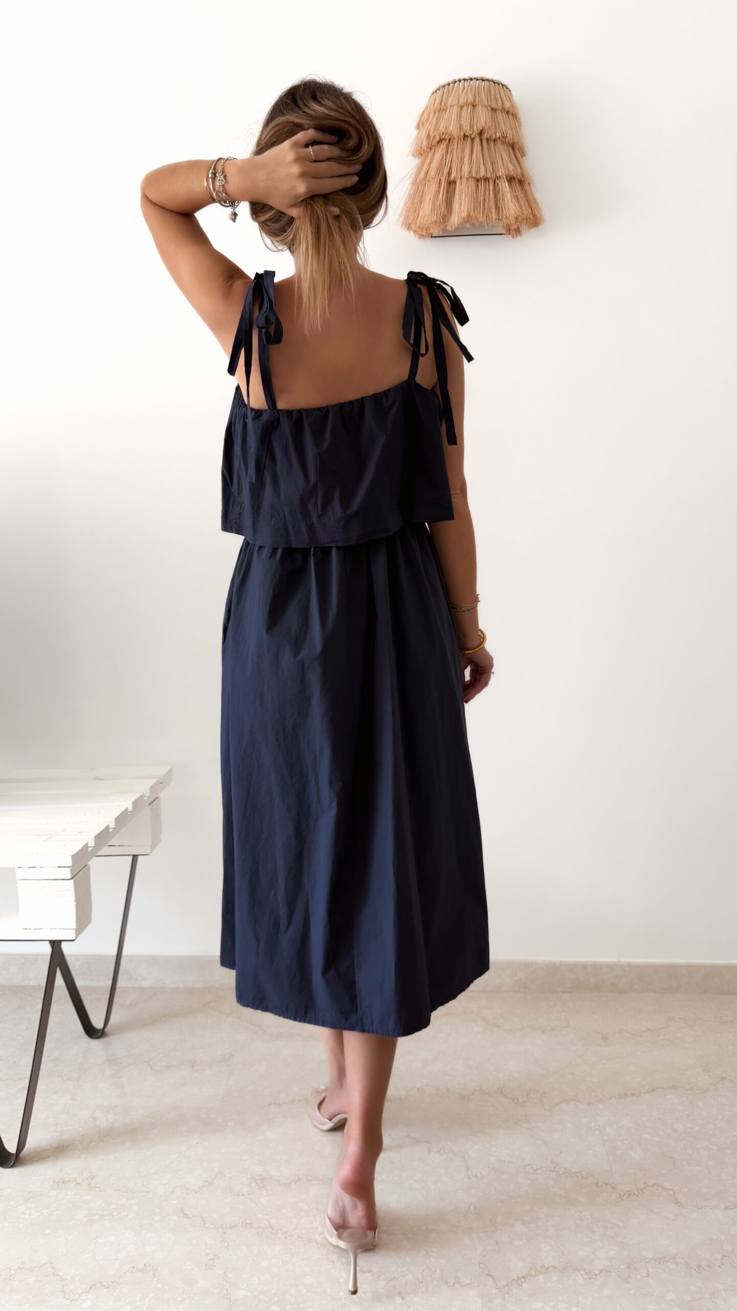 Robe midi bleu marine pour femme à bretelles nouées, coupe ample et fluide avec poches, style bohème chic et élégant.
