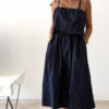 Robe midi bleu marine pour femme à bretelles nouées, coupe ample et fluide avec poches, style bohème chic et élégant.