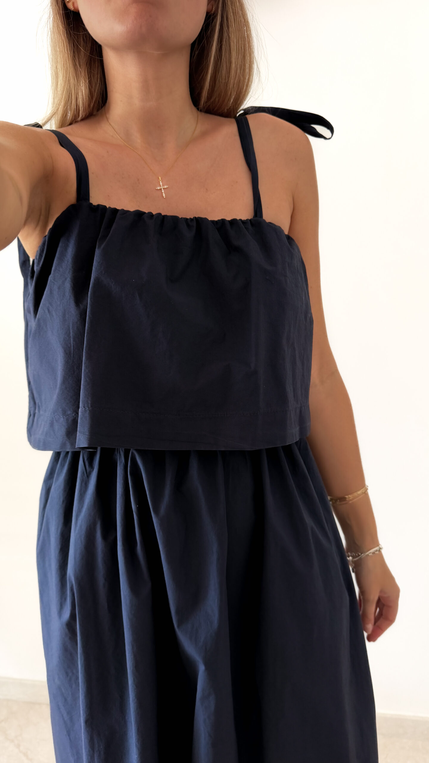 Robe midi bleu marine pour femme à bretelles nouées, coupe ample et fluide avec poches, style bohème chic et élégant.