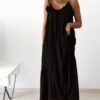 Robe longue noire à fines bretelles pour femme, coupe ample et fluide avec détails pompons, style bohème chic.