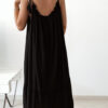 Robe longue noire à fines bretelles pour femme, coupe ample et fluide avec détails pompons, style bohème chic.