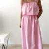 Robe midi rose poudré pour femme à bretelles nouées, coupe ample et fluide avec poches, style bohème chic et romantique.