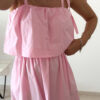 Robe midi rose poudré pour femme à bretelles nouées, coupe ample et fluide avec poches, style bohème chic et romantique.