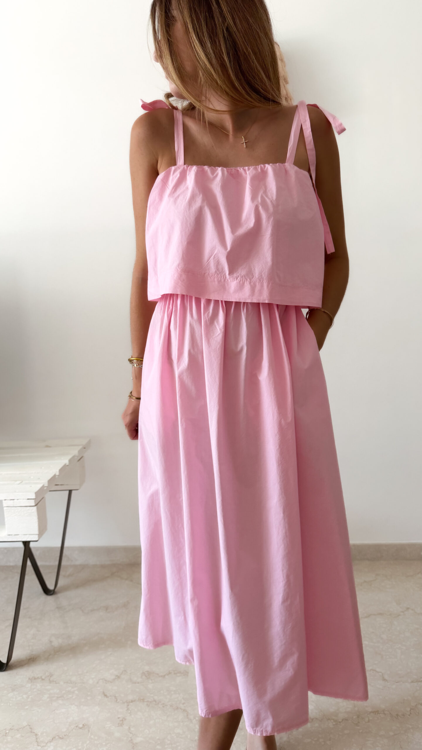 Robe midi rose poudré pour femme à bretelles nouées, coupe ample et fluide avec poches, style bohème chic et romantique.