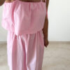 Robe midi rose poudré pour femme à bretelles nouées, coupe ample et fluide avec poches, style bohème chic et romantique.