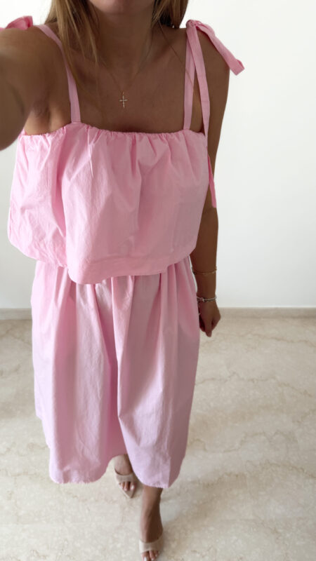 Robe midi rose poudré pour femme à bretelles nouées, coupe ample et fluide avec poches, style bohème chic et romantique.