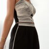 Ensemble femme noir composé d'un top texturé blanc et noir à bretelles et d'un pantalon fluide taille haute, style chic et élégant.