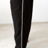 Ensemble femme noir composé d'un top texturé blanc et noir à bretelles et d'un pantalon fluide taille haute, style chic et élégant.