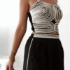 Ensemble femme noir composé d'un top texturé blanc et noir à bretelles et d'un pantalon fluide taille haute, style chic et élégant.