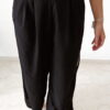 Ensemble femme noir composé d'un top texturé blanc et noir à bretelles et d'un pantalon fluide taille haute, style chic et élégant.