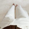 Pantalon femme écru taille haute coupe large avec débardeur blanc imprimé homard rouge, tenue estivale chic et décontractée.