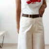 Pantalon femme écru taille haute coupe large avec débardeur blanc imprimé homard rouge, tenue estivale chic et décontractée.