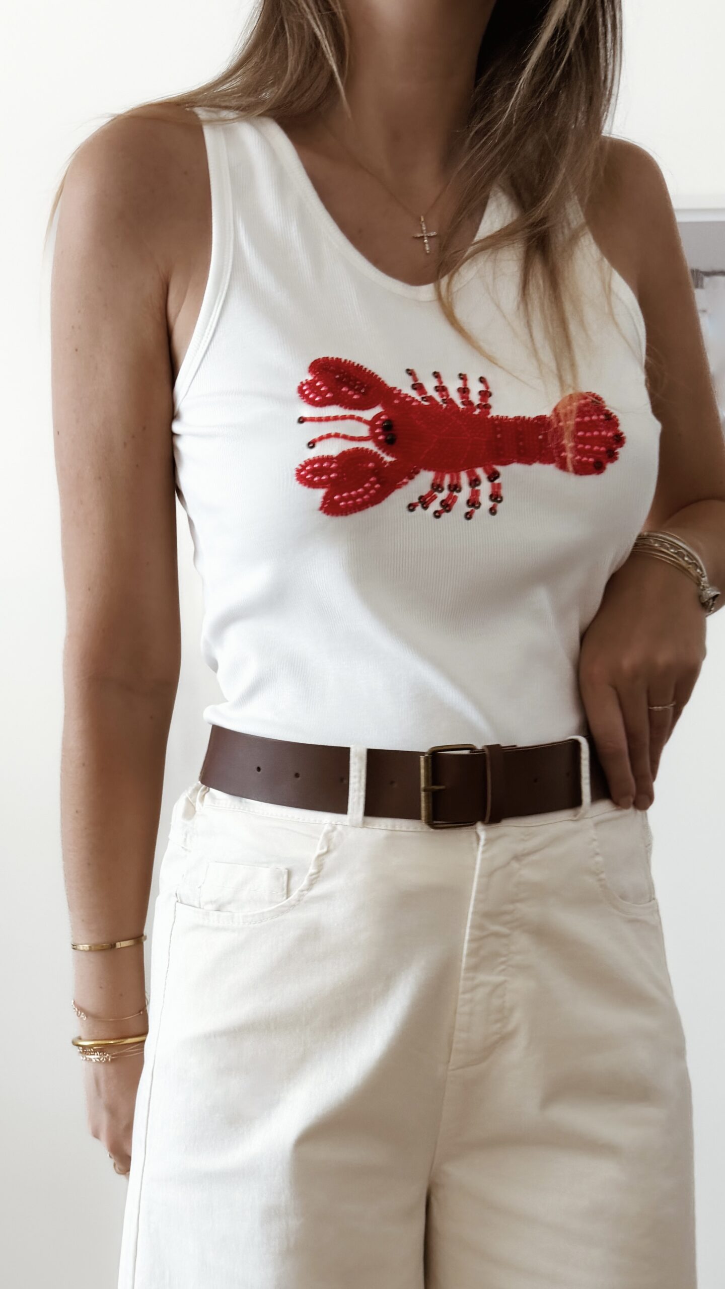 Débardeur femme blanc côtelé avec homard rouge brodé en perles, coupe près du corps, style chic et tendance pour l'été.