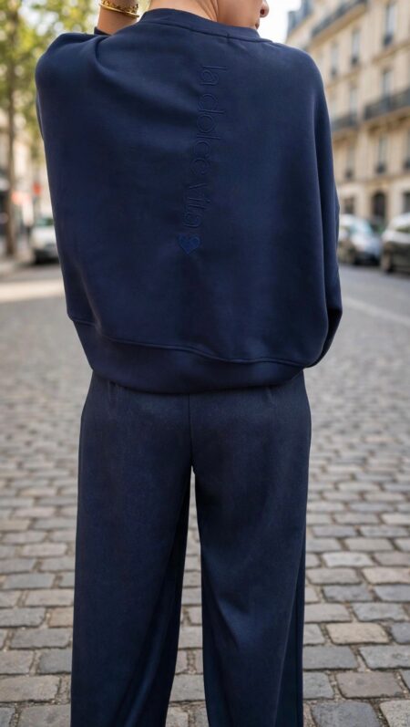 Sweat-shirt oversize femme bleu marine avec inscription Dolce Vita dans le dos, porté avec un pantalon fluide assorti.