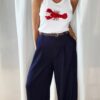 Pantalon bleu femme coupe large et fluide, porté avec un débardeur blanc, style chic et élégant