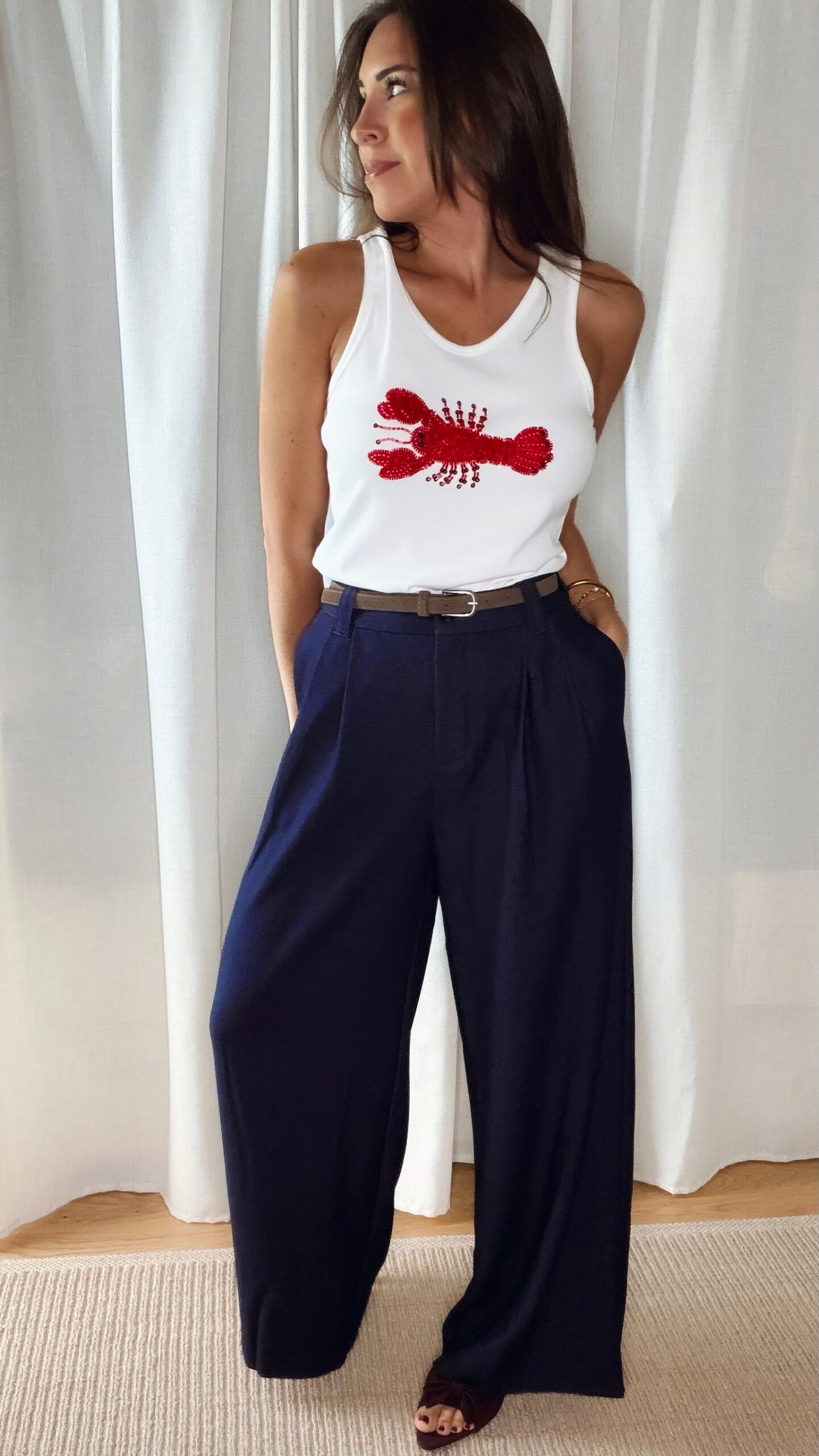 Pantalon bleu femme coupe large et fluide, porté avec un débardeur blanc, style chic et élégant