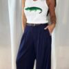 Pantalon bleu femme coupe large et fluide, porté avec un débardeur blanc, style chic et élégant