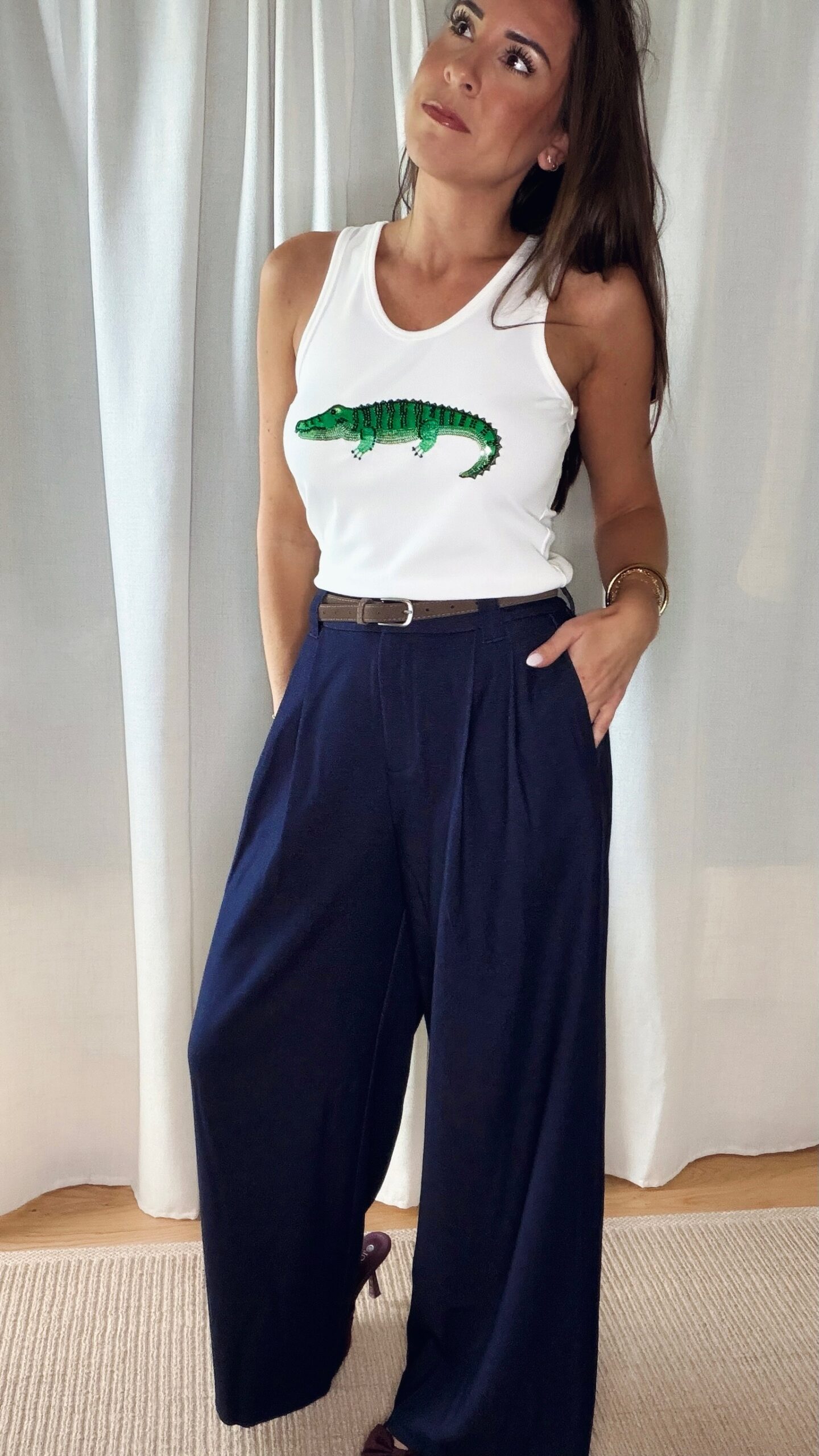 Pantalon bleu femme coupe large et fluide, porté avec un débardeur blanc, style chic et élégant
