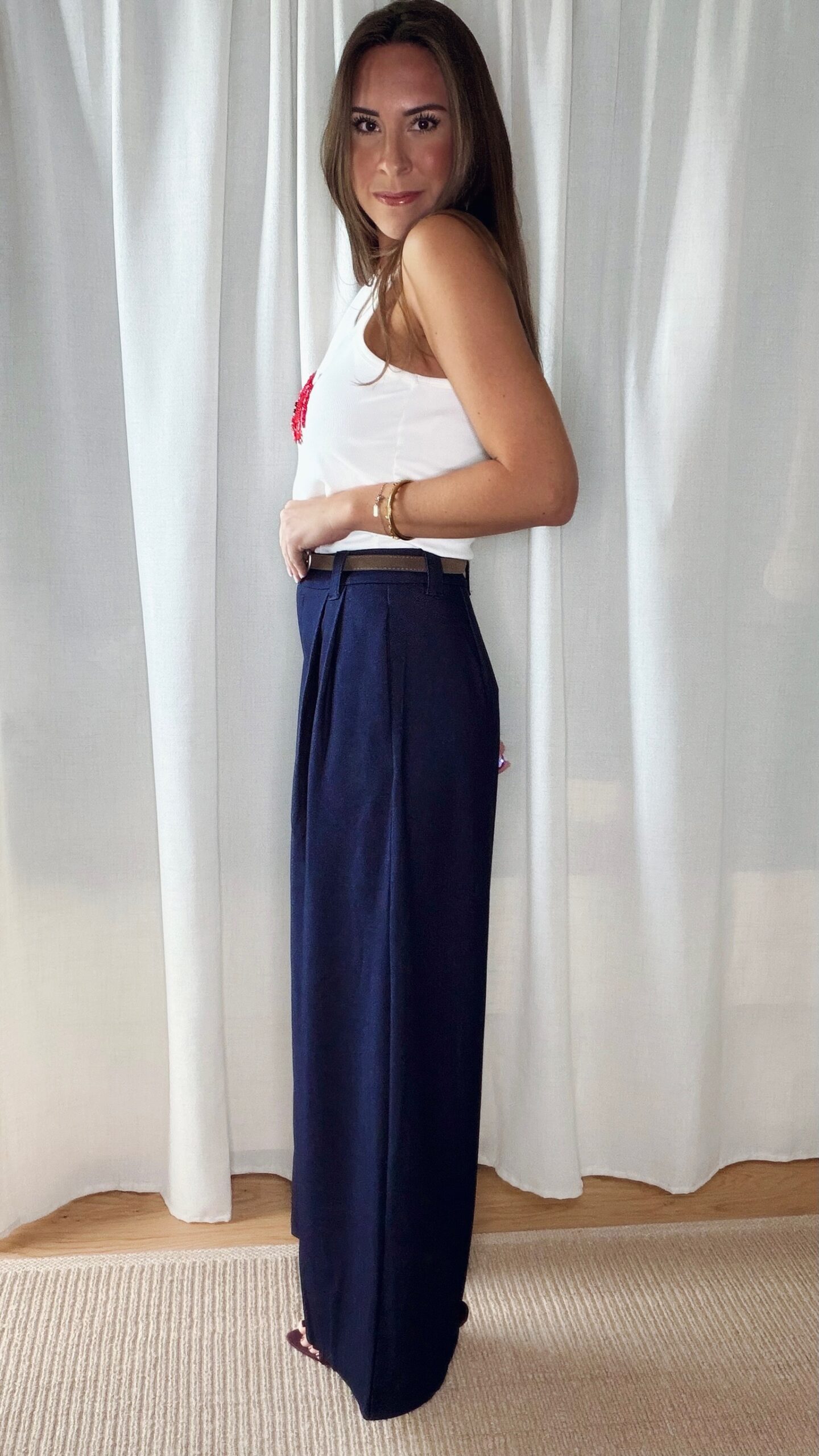 Pantalon bleu femme coupe large et fluide, porté avec un débardeur blanc, style chic et élégant