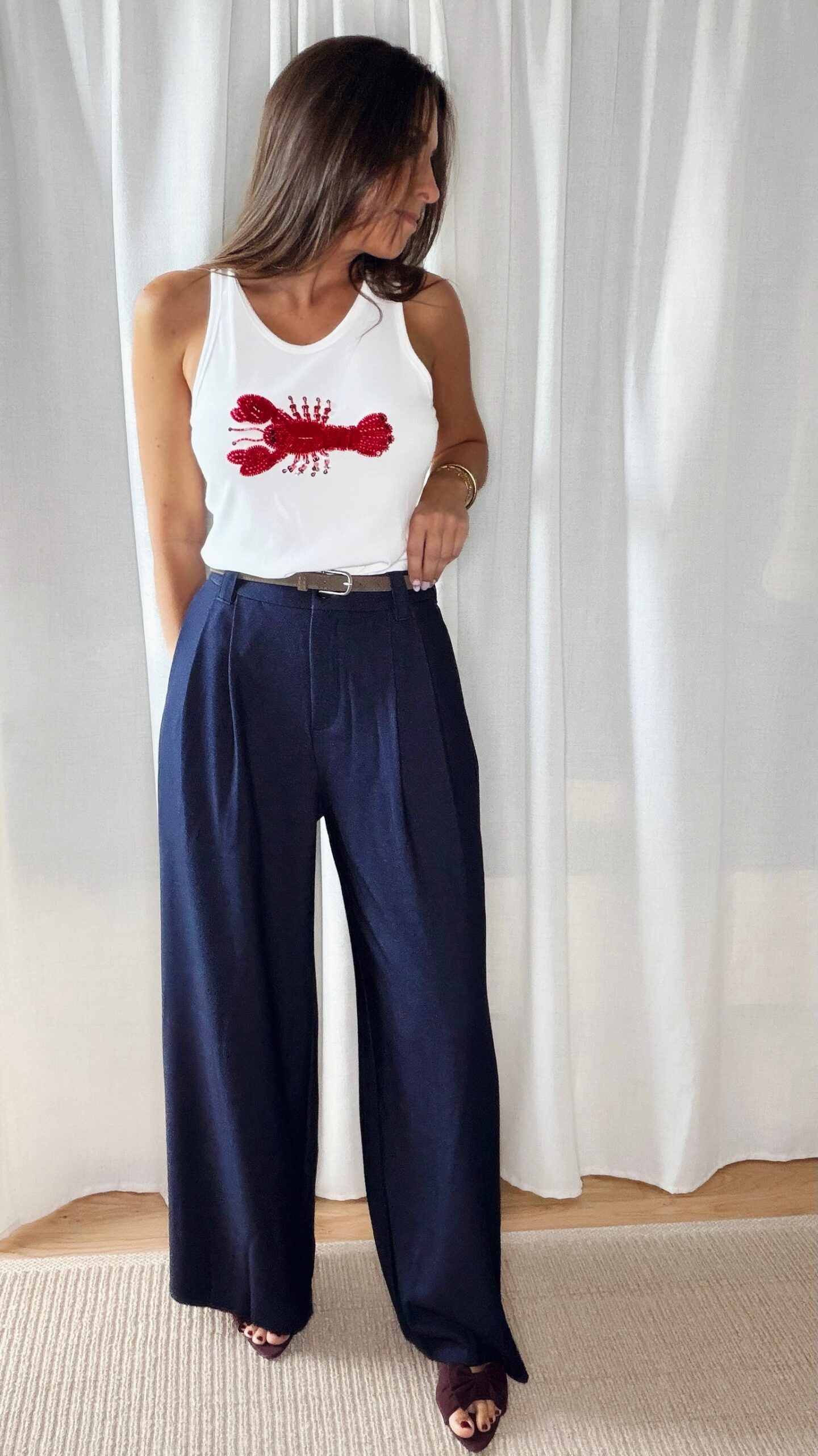 Pantalon bleu femme coupe large et fluide, porté avec un débardeur blanc, style chic et élégant