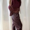 Sac bordeaux femme à franges avec clous dorés, porté à l’épaule, style bohème chic