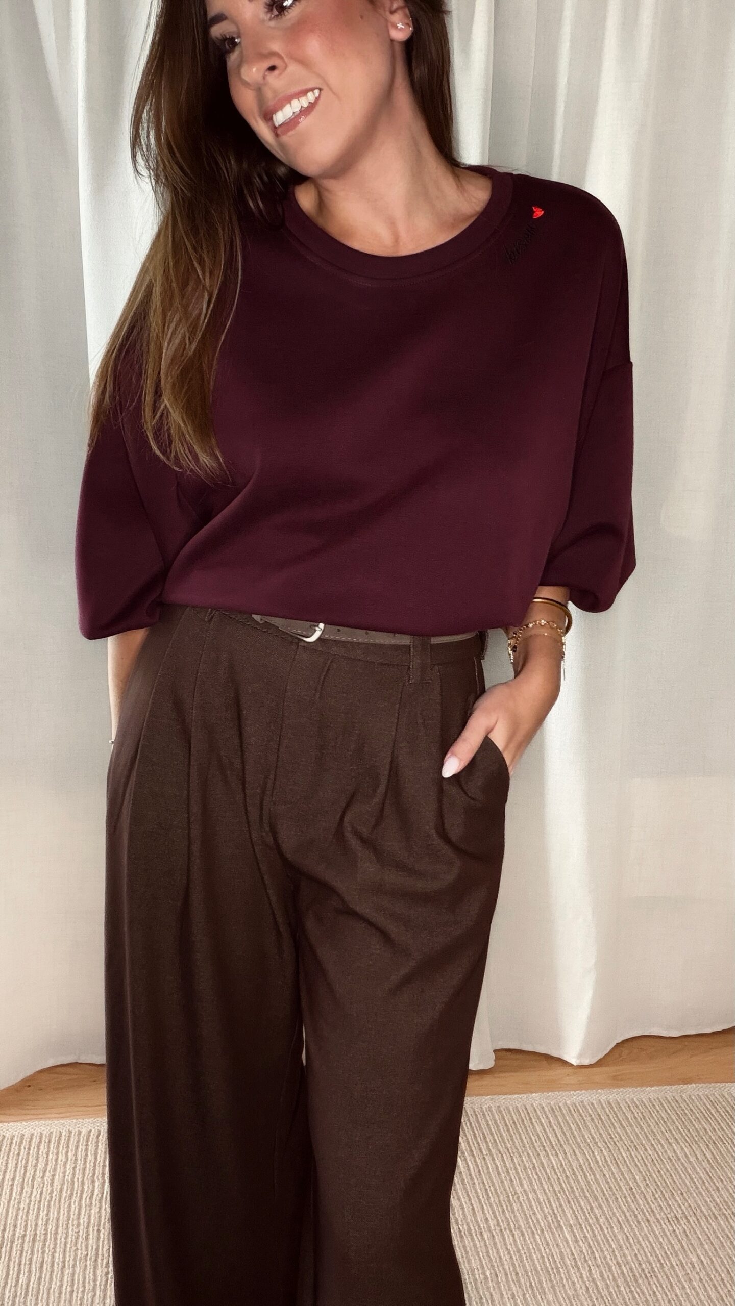 Pantalon marron femme coupe large et fluide, porté avec un sweat bordeaux, style chic et élégant