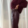 Sweat bordeaux femme porté avec un pantalon marron fluide et un sac à franges, tenue chic et tendance