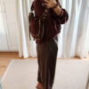 Sac bordeaux femme à franges avec clous dorés, porté à l’épaule, style bohème chic