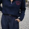 Pull femme bleu marine Los Angeles avec col montant zippé et inscription rouge sur la poitrine, associé à un pantalon large bleu marine à pinces.