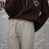 Pull marron femme Los Angeles à col montant zippé avec pantalon large gris taupe, une tenue féminine chic et tendance.