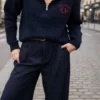 Pull femme bleu marine Los Angeles à col montant zippé avec inscription rouge sur la poitrine, porté avec un pantalon large bleu marine.