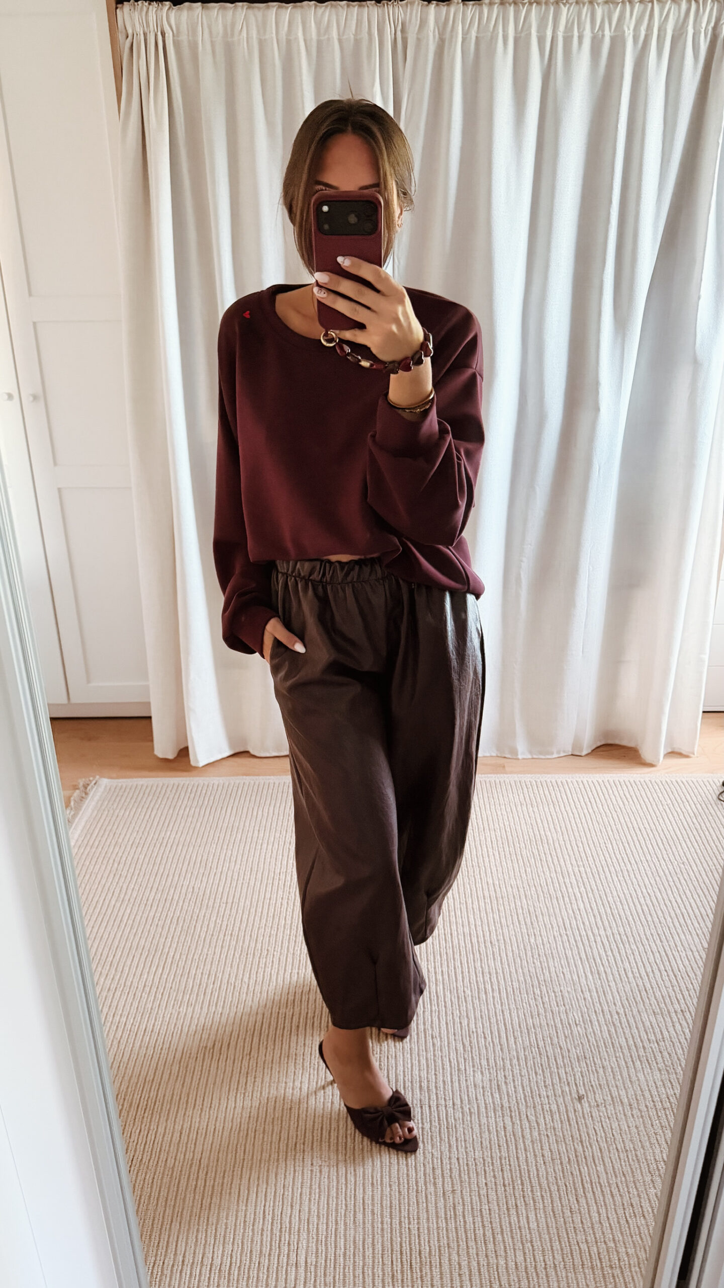 Sweat bordeaux femme coupe décontractée porté avec un pantalon marron, look casual chic